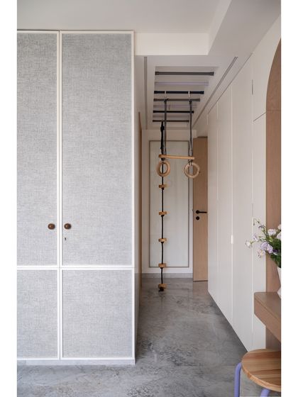 This daughter's bedroom includes a playful nook with monkey bars for gymnastics, perfectly complemented by fun polka-dotted curtains. The design proves that a room can be both beautiful and a space for active play.