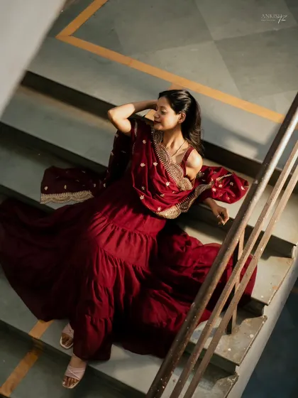 Using a staircase for a high-angle shot, this portrait emphasizes the beautiful flow and rich color of her maroon ethnic dress.