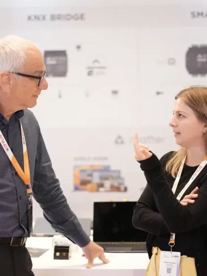 Two professionals discuss the technical specifications of a smart core system. The expo is a prime venue for in-depth conversations between manufacturers and system integrators.