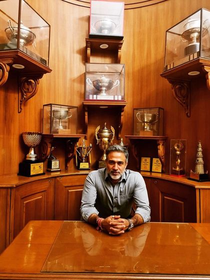 Seated in a room that holds memories of many achievements. Each trophy represents a milestone in a long journey, reminding me of the effort and dedication this profession demands.