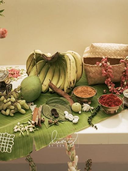 A traditional offering table with bananas, mango, and spices laid out on a banana leaf, part of a heritage-themed engagement.