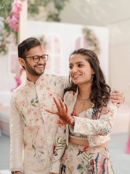 Shared laughter and stolen glances. The couple's coordinating floral outfits and her radiant makeup create a perfect picture.