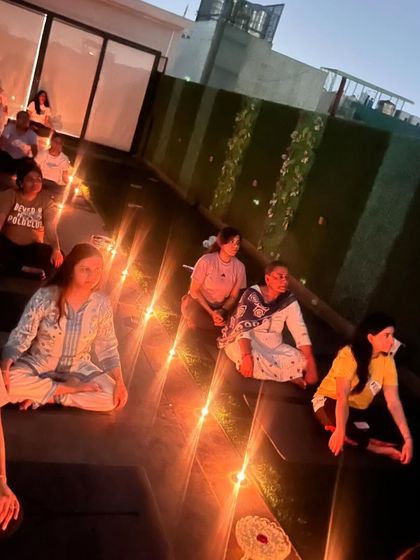 A beautiful, warm glow from the candles illuminates the faces of our students during a rooftop meditation. Each person is on their own journey, yet we are all connected in this shared moment of peace.