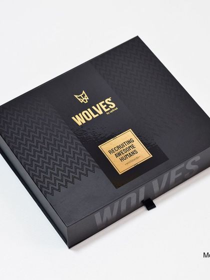 The unboxing experience matters. For the "Wolves" welcome kit, we designed a premium black magnetic box with gold foil branding that reads "Recruiting Awesome Humans," setting a high-end tone before the gifts are even revealed.