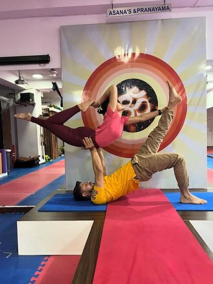 This acro yoga pose, often called "Throne" or "Chair", is a testament to balance and strength. The base creates a solid foundation for the flyer, who holds a graceful pose above.