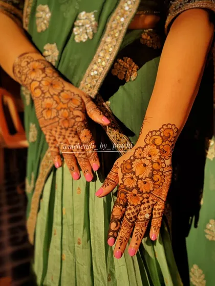 This floral mehendi design truly glows in the sunlight. The pattern covers both the front and back of the hands, showcasing how a well-developed stain can make even simple floral patterns look stunning.