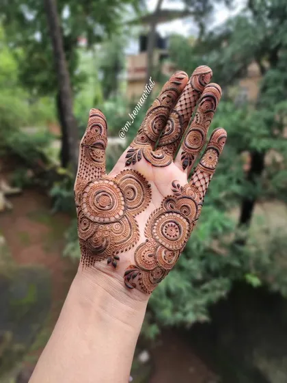 This mandala design looks so beautiful against the natural green background. It's a reminder of how henna connects us to nature.