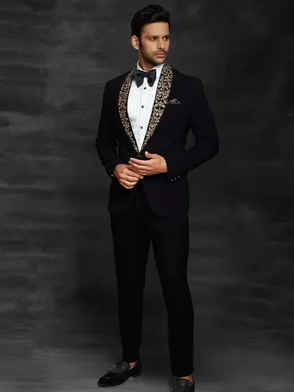 For a sharp reception or cocktail party look, nothing beats a custom-fit tuxedo. This black tuxedo features a unique embroidered shawl lapel, giving a modern twist to a classic style. It's all about looking sharp and sophisticated.
