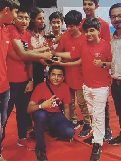 The team huddles around their "Best Team in Research Innovation" trophy. This award recognizes their ability to identify a real-world problem, research it thoroughly, and propose an inventive solution.