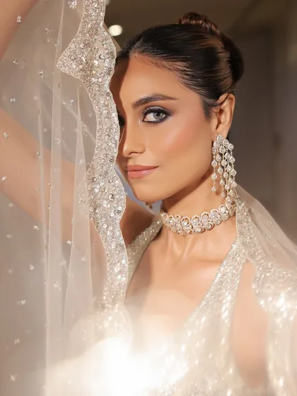 An artistic shot through the sheer, sparkling cape. This image captures the ethereal yet glamorous feel of this stunning reception look.