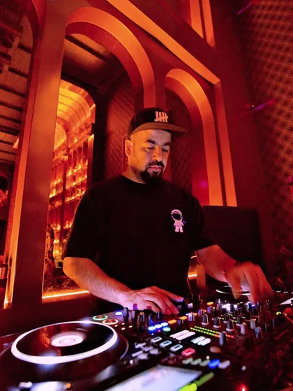 On the decks at 10SpeakEasy, surrounded by the club's cool, retro decor.
