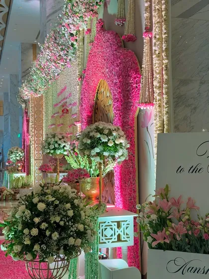 A detail of the entrance, where a massive arch made of pink flowers creates a dramatic statement. This is how we ensure every glance reveals a new layer of beauty.