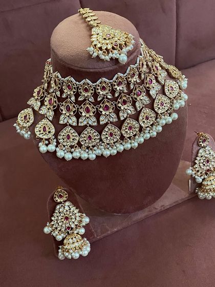 The complete red and pearl kundan set, including the maang tikka.