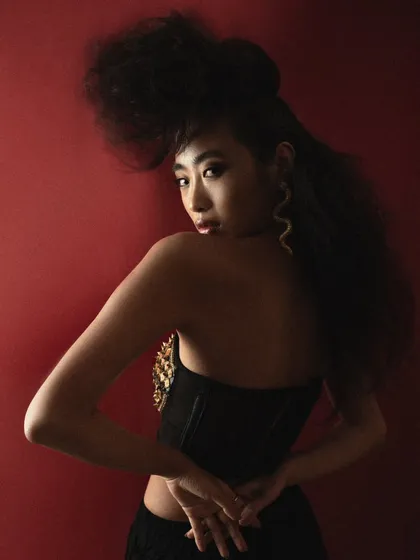 A profile shot from the 'Ethereal' hair editorial, showing the intricate structure and texture of the hairstyle from a different angle. The lighting highlights the silhouette against the red background.