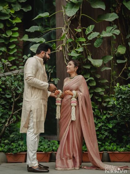 A full-length portrait of the couple in a garden setting, sharing a quiet moment. The natural environment adds a touch of serenity.