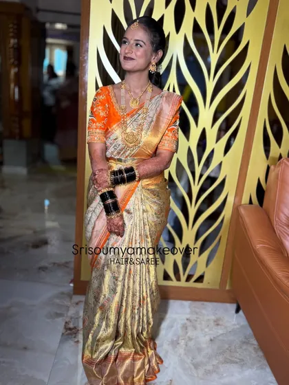 A full-length view of a stunning South Indian bride. The expert saree draping and perfectly coordinated jewellery create a majestic and elegant silhouette.