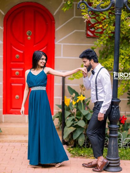 A classic romantic gesture in front of the bright red door, a charming and popular spot for couple photos.