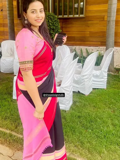Another look at the client's red and black saree, this time with a pink pallu, showing the versatility of the custom blouse.