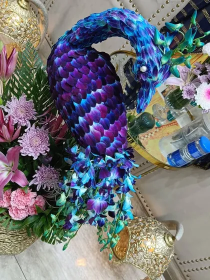 A close-up look at the intricate work involved in our custom floral sculptures. Here, you can see how individual orchid petals are layered to create the head and neck of a peacock, showcasing our team's attention to detail and artistry.
