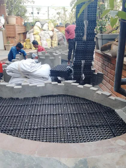 This image shows the different components coming together: the base layer of drain cells, the construction of planter walls, and bags of soil ready for the next stage.