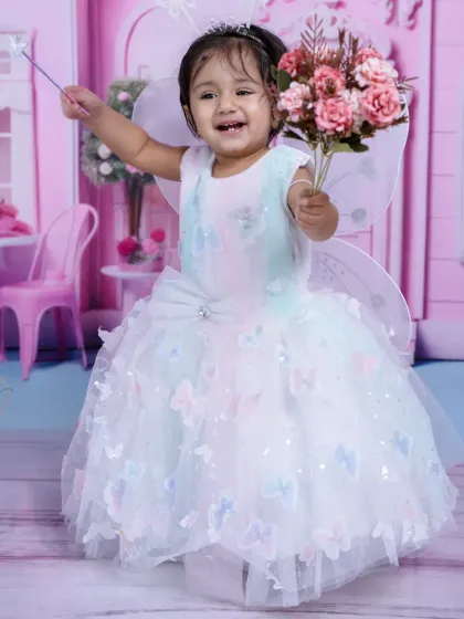 A real-life fairy princess. This toddler is having a magical time in her butterfly dress, complete with wings and a wand.