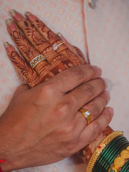 A close-up on the couple's hands, showcasing their engagement rings. This shot symbolizes their union and the promise they've made to each other.