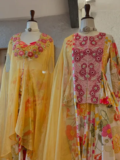 A focus on two of the floral ensembles, one with a dramatic cape and the other with an embroidered yoke, showcasing the versatility of the collection.