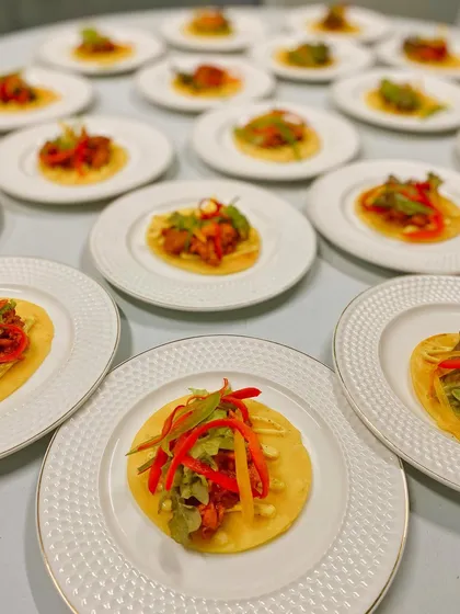 A perspective shot showing the meticulous plating of our butter chicken tacos, ensuring consistency and elegance for every guest.