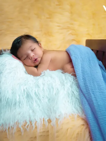 We use a variety of simple, safe props like this tiny bed to add a touch of charm to our newborn portraits. The focus always remains on the peaceful, sleeping baby.