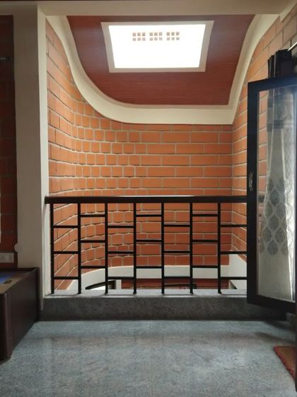 A small balcony or landing with a curved ceiling detail, lit by a skylight, creating an interesting architectural moment.