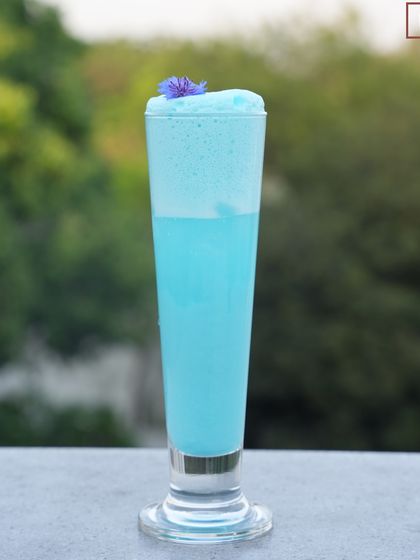 Our Blue Velvet cocktail, standing tall and elegant. It's a sweet, tropical-flavoured drink that is perfect for summer sipping.