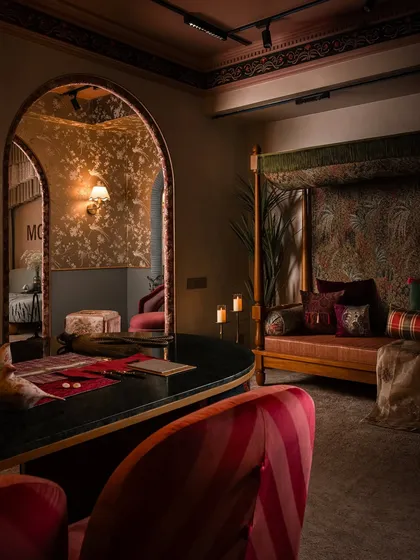 We love creating distinct moods within a single space. This corner of the studio was designed to be bold and expressive, with a maximalist approach that layers rich colors, dramatic lighting, and custom furniture to create an immersive and memorable client interaction zone.
