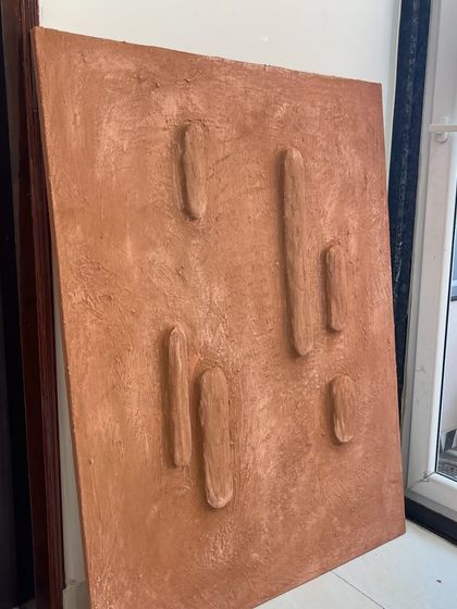 The terracotta panel from a different angle, showing its solid, monolithic quality. It's a simple yet powerful design.