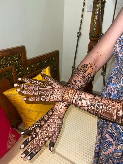 A full view of the intricate bridal mehendi, showing the detailed work from fingertips to elbows.