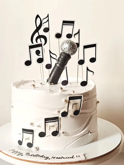 A simple and elegant music-themed cake, decorated with a microphone and cascading musical notes. Perfect for a singer or music enthusiast.