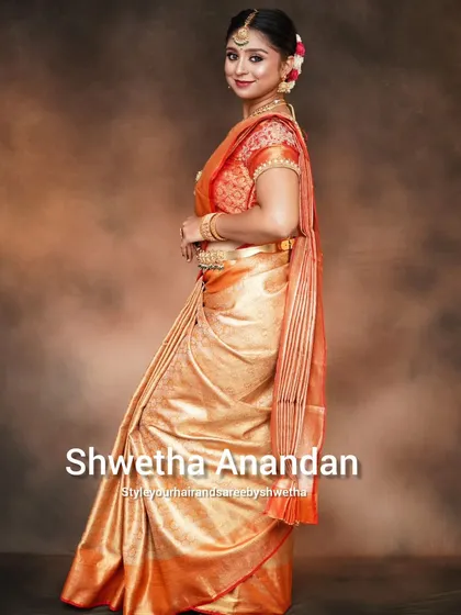 A side profile of the golden bridal saree look, showing the detail in the hairstyle and the elegant fall of the pallu. Every angle matters in professional draping.