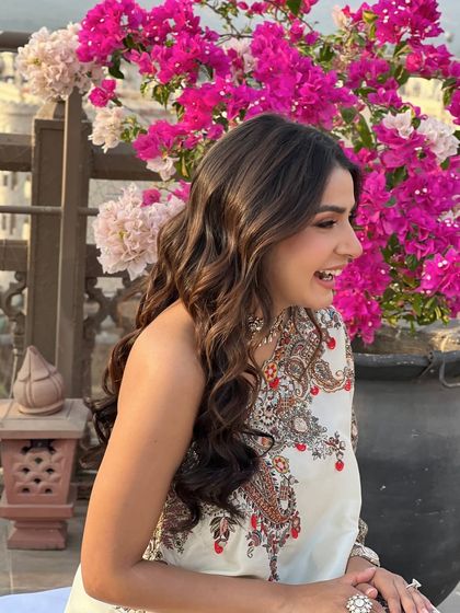 A joyful shot of the bride, her flowing waves perfect for the sunny Mehandi event.