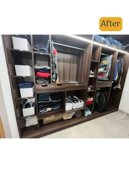 After organizing, the same closet now has clear shelves and uses white bins to neatly store folded clothes and accessories, creating a bright and orderly space.