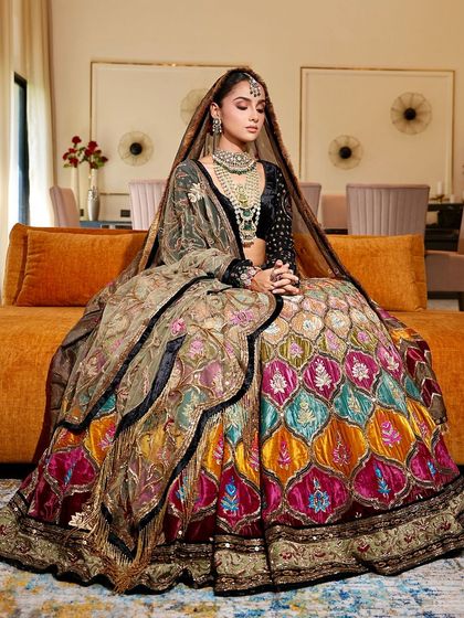 A stunning portrait of the bride, capturing the full splendor of her multi-hued lehenga. The makeup is designed to be elegant and understated, ensuring she looks radiant and feels like herself.