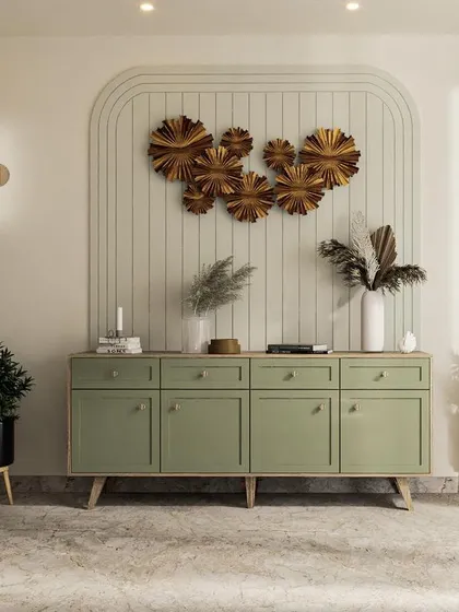 The crockery unit in the Japandi dining room, painted in a soft sage green with simple wooden knobs, set against an arched wall detail.