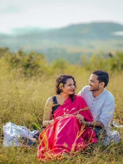 A peaceful picnic scene in a vast meadow, showcasing a relaxed and natural interaction between the couple.