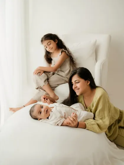 Three siblings posing together in a bright, naturally lit studio. This is a lovely example of a lifestyle kids photoshoot.