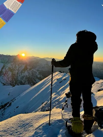 A trekker watching the sunrise over a snowy landscape. These are the moments we live for.