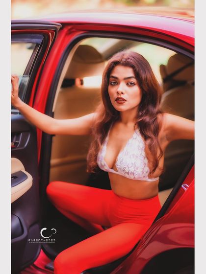 A bold and confident pose in a car. This shot is about owning your power and sensuality, with the red and white creating a striking color palette.