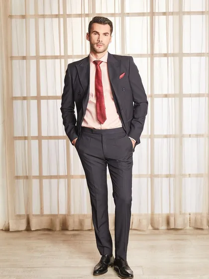 A full-length portrait of the double-breasted pinstripe suit. The silhouette is strong and masculine, tailored to create a flattering V-shape torso.