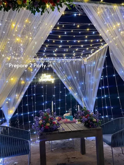 The interior of our romantic dining cabana, showing the table set for two with floral arrangements and candles. In the background, a custom neon sign adds a personal touch to the celebration.