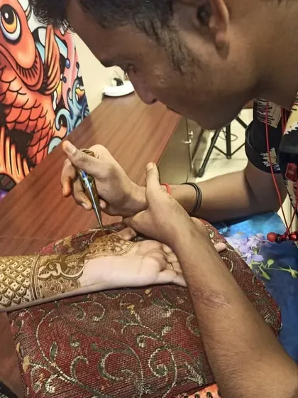 One of our professional artists applying an intricate henna design at a client's home. Our team provides a comfortable and hassle-free mehndi experience anywhere in Mumbai and Thane.