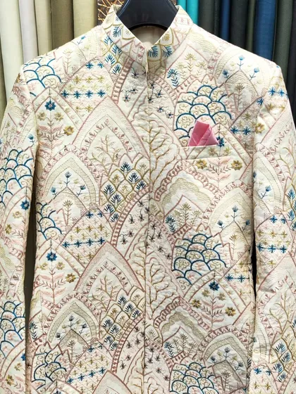 A detailed shot of the beautifully embroidered open Jodhpuri jacket fabric, highlighting the multi-colored thread work.