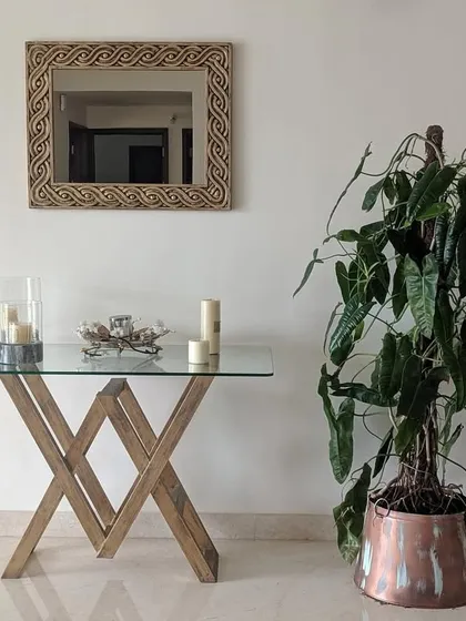 A tall Philodendron plant in a copper planter adds a touch of organic elegance to this entryway console. I help select indoor plants that fit the scale and style of your home decor.