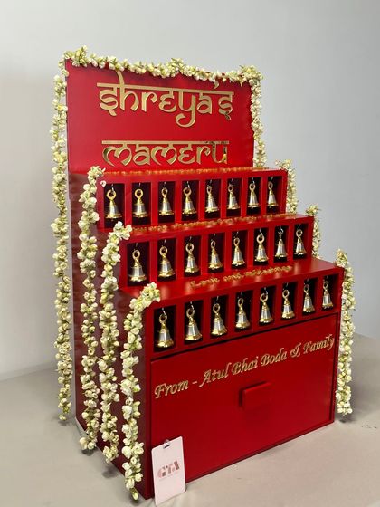 This angle highlights the beautiful cascade of fresh jasmine flowers adorning the side of the traditional red Mameru gifting structure.